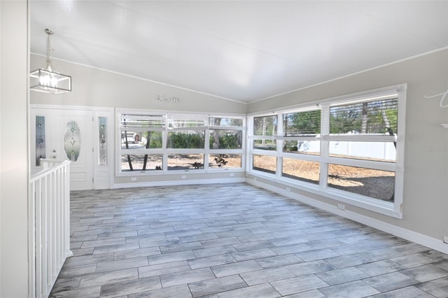 unfurnished sunroom featuring lofted ceiling and an inviting chandelier