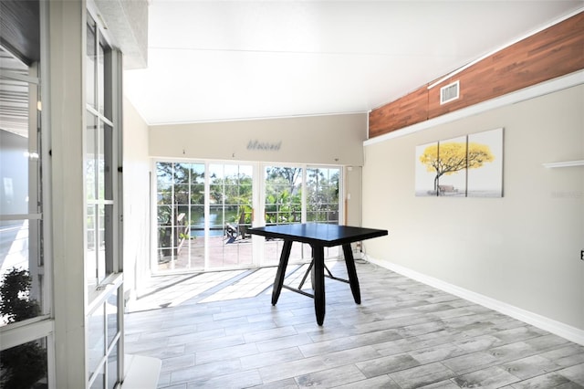 interior space with vaulted ceiling, wood finished floors, visible vents, and baseboards