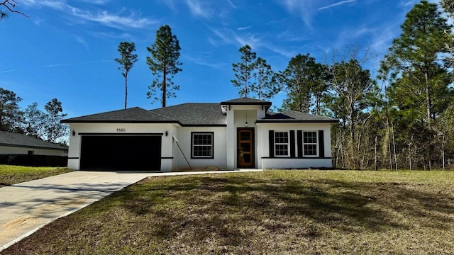 view of front of house featuring a garage, concrete driveway, a front yard, and stucco siding