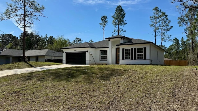 view of front of house featuring a garage, fence, driveway, stucco siding, and a front lawn