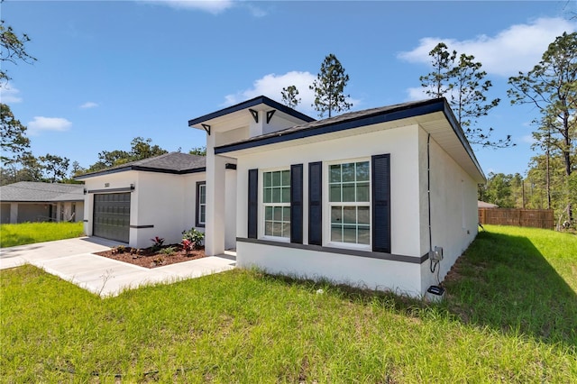 view of front of property with fence, an attached garage, a front lawn, stucco siding, and concrete driveway