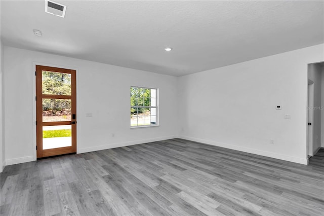 unfurnished room featuring visible vents, recessed lighting, baseboards, and wood finished floors
