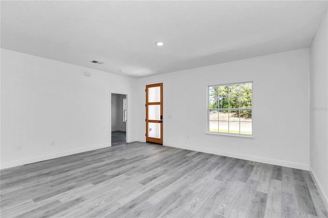 empty room featuring visible vents, recessed lighting, light wood-style flooring, and baseboards
