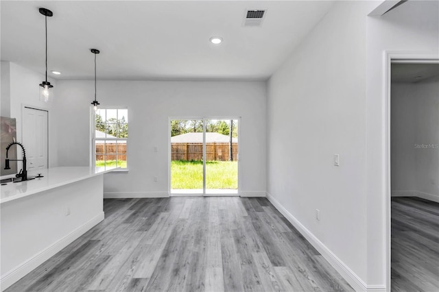 unfurnished dining area featuring recessed lighting, baseboards, and wood finished floors