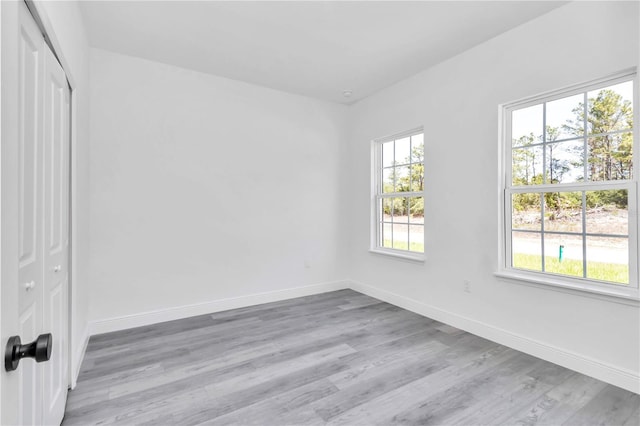 unfurnished bedroom featuring baseboards, a closet, and light wood finished floors