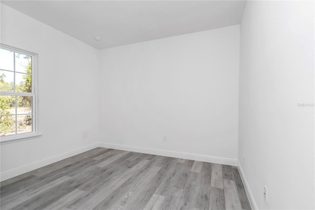 empty room featuring baseboards and light wood-style flooring