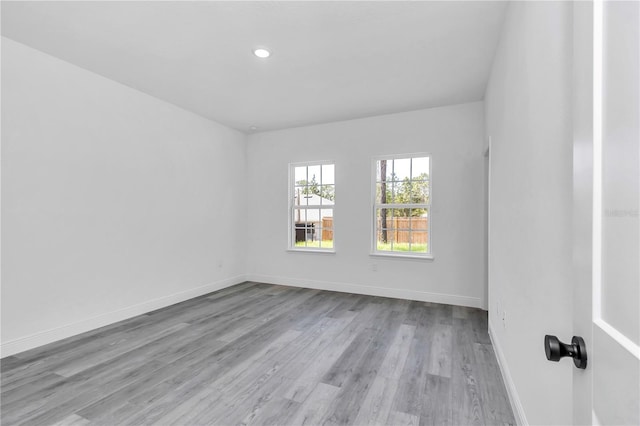 empty room featuring baseboards, recessed lighting, and wood finished floors