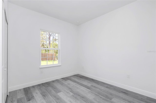 empty room with baseboards and wood finished floors