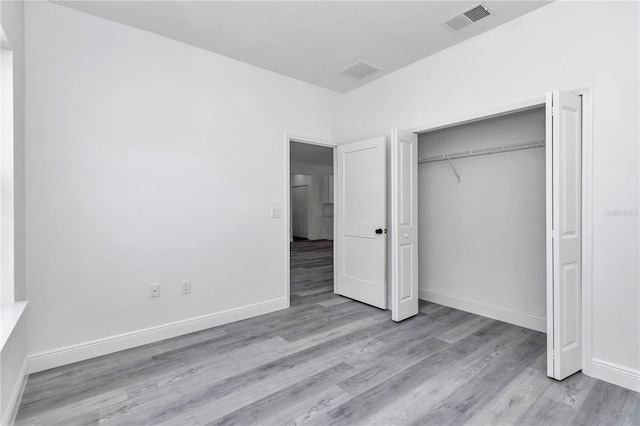 unfurnished bedroom featuring visible vents, baseboards, and wood finished floors