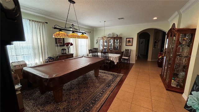 rec room with arched walkways, light tile patterned floors, visible vents, ornamental molding, and a textured ceiling