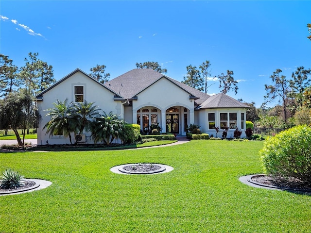 view of front of property featuring a front lawn, french doors, and stucco siding