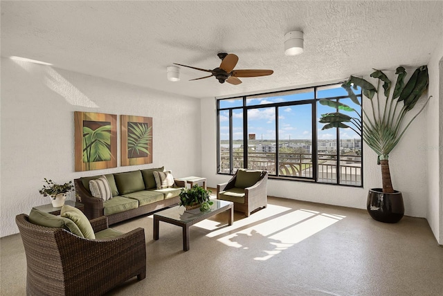 living area featuring a ceiling fan and a textured ceiling