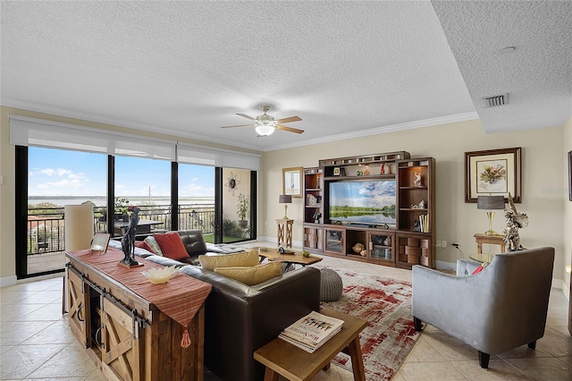 living room featuring a ceiling fan, ornamental molding, a textured ceiling, and baseboards