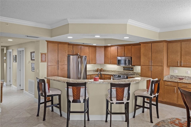 kitchen with brown cabinetry, a kitchen bar, and stainless steel appliances