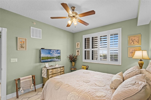 bedroom featuring baseboards, visible vents, a ceiling fan, a textured ceiling, and carpet flooring