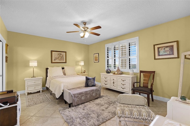 bedroom with a textured ceiling, ceiling fan, light tile patterned floors, and baseboards