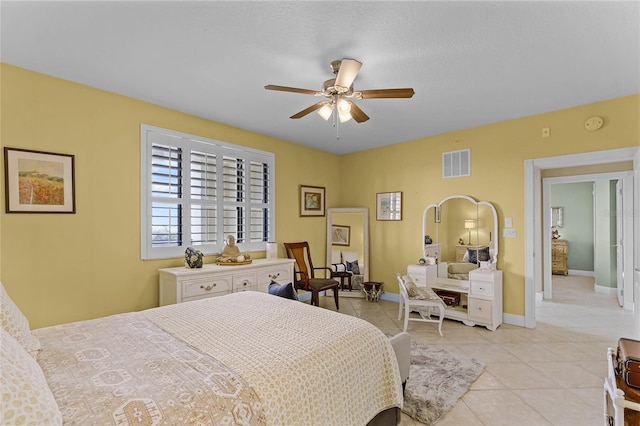 bedroom with a ceiling fan, visible vents, baseboards, and light tile patterned flooring