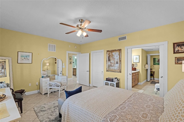 bedroom featuring light tile patterned floors, visible vents, and connected bathroom