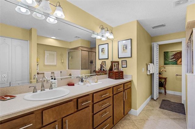 full bathroom with vanity, a shower stall, visible vents, and tile patterned floors