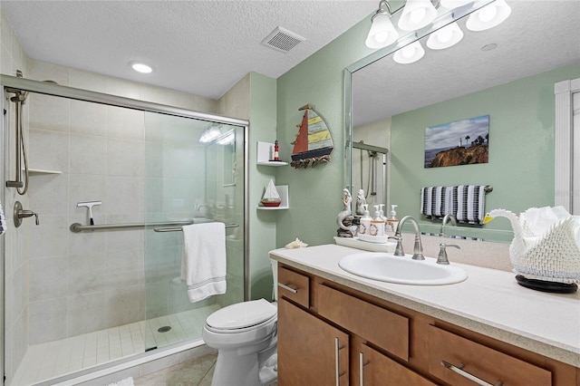 full bath with visible vents, toilet, a shower stall, a textured ceiling, and vanity