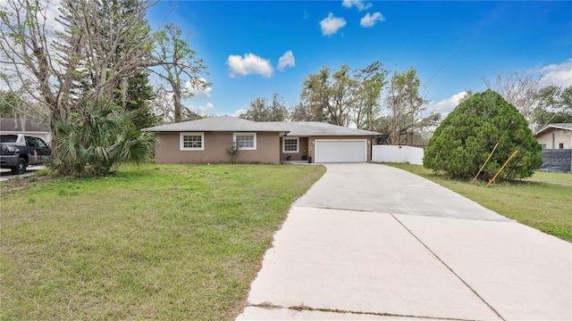 ranch-style home with a garage, driveway, a front lawn, and stucco siding