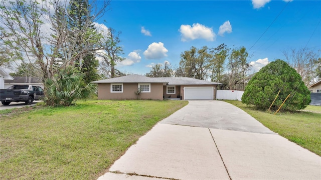 ranch-style home with driveway, a front lawn, an attached garage, and stucco siding