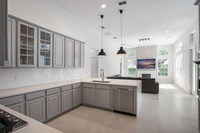 kitchen with a sink, dishwasher, a peninsula, and gray cabinets