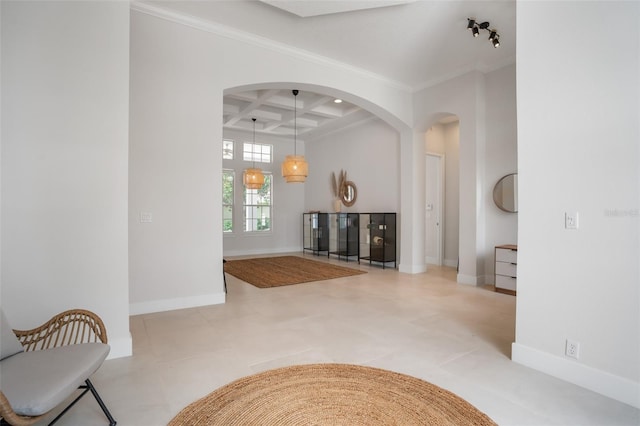 interior space featuring baseboards, arched walkways, coffered ceiling, and ornamental molding