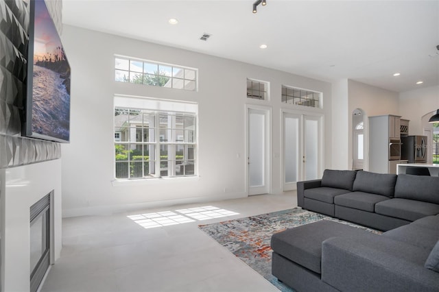 living area with a glass covered fireplace, plenty of natural light, and recessed lighting