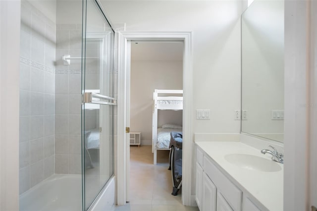 ensuite bathroom featuring combined bath / shower with glass door, ensuite bathroom, vanity, and tile patterned flooring