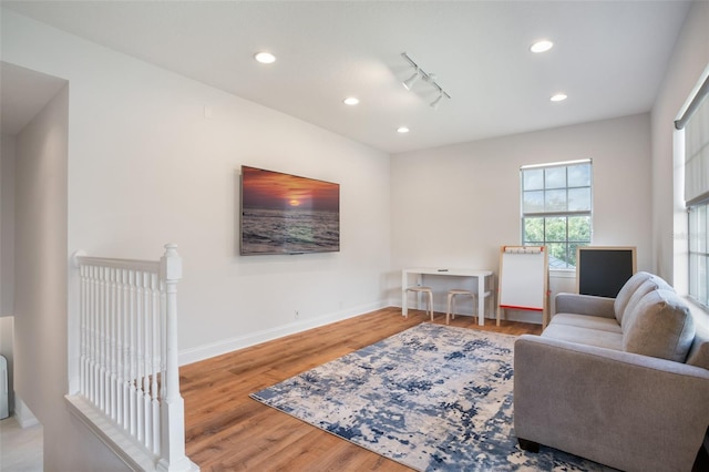 living room with rail lighting, recessed lighting, wood finished floors, and baseboards