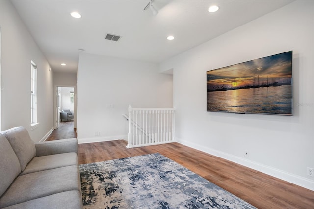 living room featuring recessed lighting, visible vents, baseboards, and wood finished floors