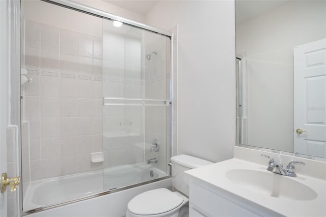 bathroom featuring vanity, toilet, and shower / bath combination with glass door