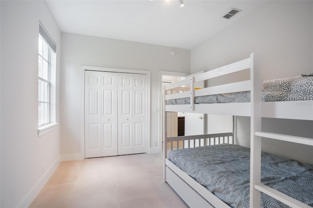 bedroom featuring baseboards, visible vents, and a closet