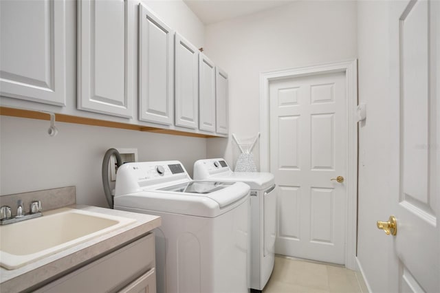 washroom with a sink, cabinet space, washing machine and dryer, and light tile patterned floors