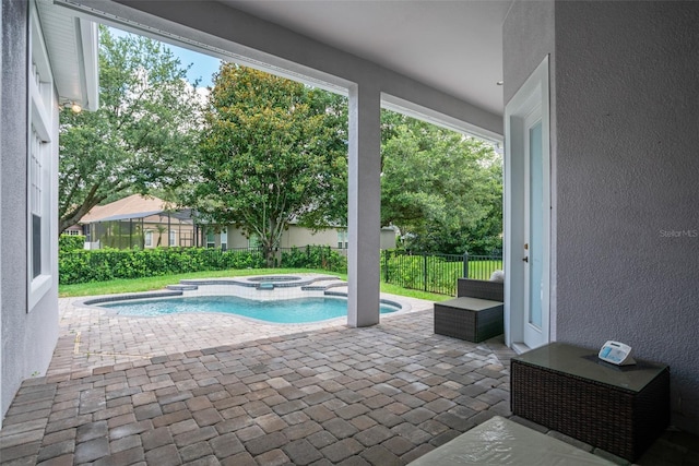 view of pool with a patio area, a pool with connected hot tub, and fence