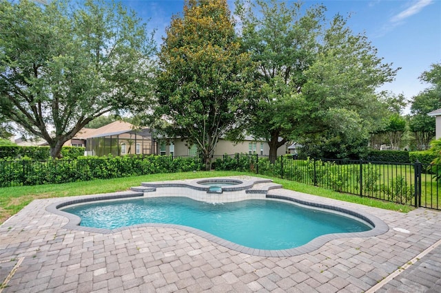 view of pool featuring a patio, fence, a lawn, and a pool with connected hot tub