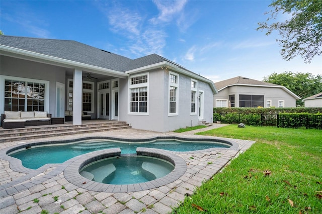 view of pool featuring a pool with connected hot tub, a lawn, an outdoor hangout area, a patio, and a ceiling fan