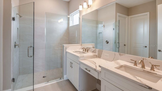 full bath featuring a stall shower, a sink, and double vanity