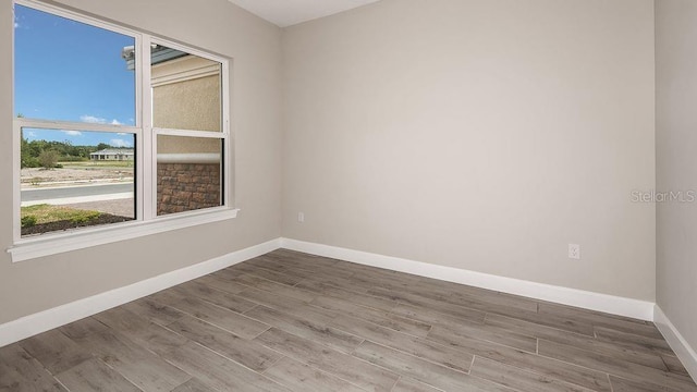 spare room with wood finished floors and baseboards