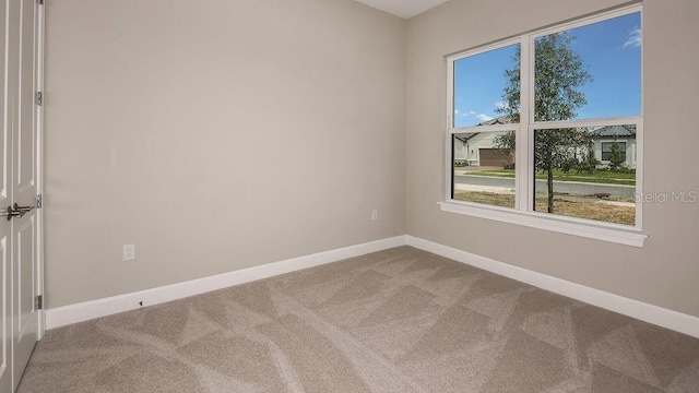 unfurnished room with carpet and baseboards