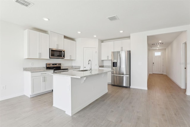 kitchen with light wood-type flooring, visible vents, appliances with stainless steel finishes, and a sink