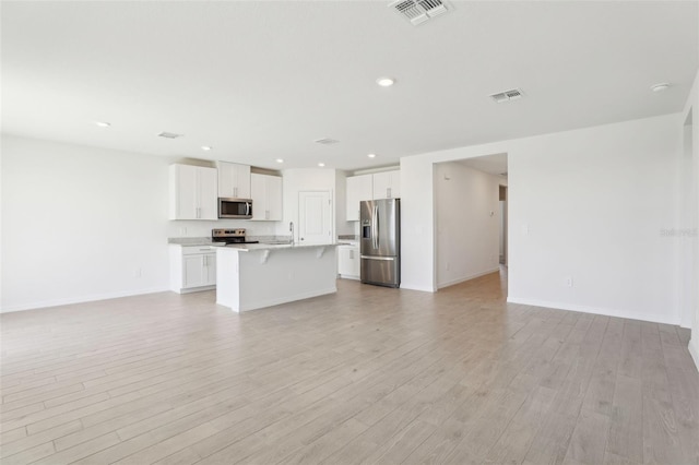 unfurnished living room with baseboards, visible vents, recessed lighting, and light wood-style floors