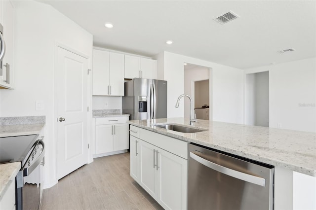 kitchen featuring white cabinets, stainless steel appliances, light wood-style flooring, a sink, and visible vents