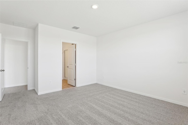 carpeted spare room featuring recessed lighting, visible vents, and baseboards
