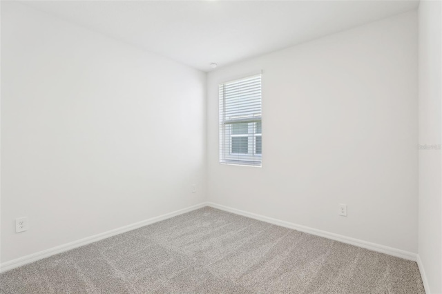 carpeted spare room featuring baseboards