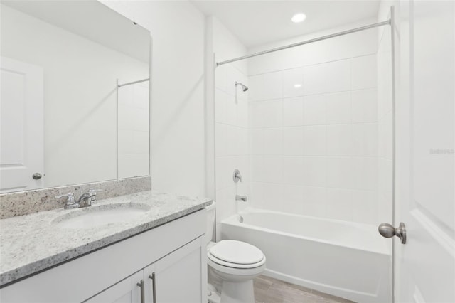 bathroom with wood finished floors, toilet, vanity, and bathing tub / shower combination