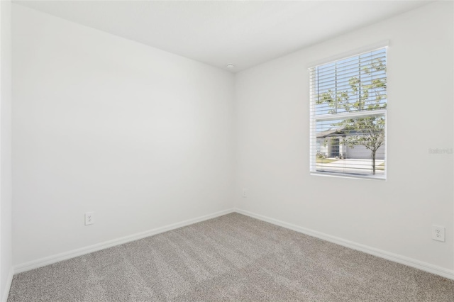 empty room featuring baseboards and carpet floors