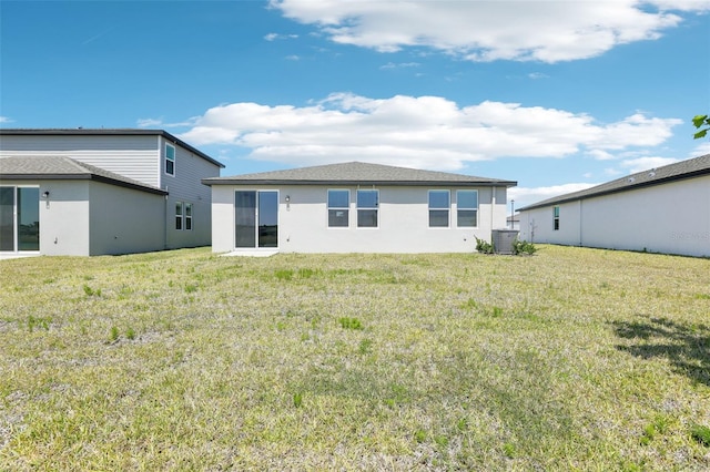 back of house with a yard, cooling unit, and stucco siding