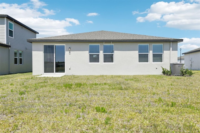 back of property featuring a yard, central AC, and stucco siding